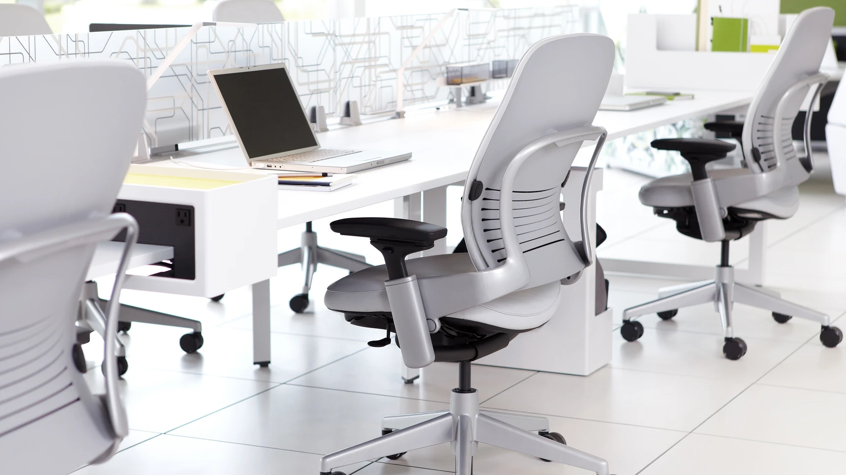 Three-Steelcase-Leap-Leather-Office-Chairs-With-Grey-Leather-And-Black-Metallic-Base-At-Desk-In-Office-Environment.webp